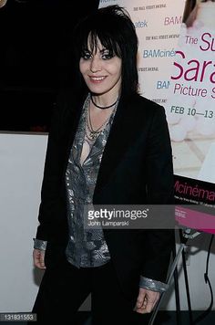 a woman with black hair standing in front of a poster for the film's premiere