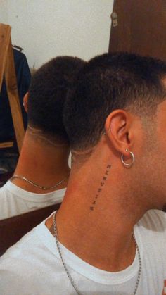 the back of a man's head with a tattoo on his left side neck