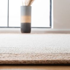 a coffee cup sitting on top of a rug next to a window