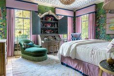 a bedroom decorated in pink, green and blue with floral wallpaper on the walls