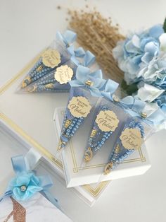 three blue and gold paper cones with name tags on them