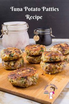 several patties stacked on top of each other on a wooden cutting board next to a jar