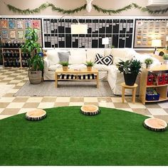 a living room filled with furniture and lots of plants on the floor in front of a checkerboard wall