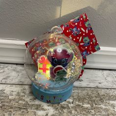 there is a glass ball on the counter next to a red and white gift bag