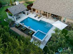 an aerial view of a house with a pool in the yard and covered patio area