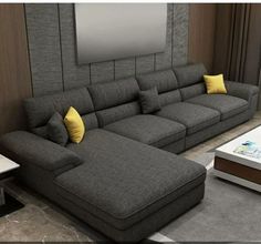 a living room with a large gray couch and yellow pillows on the back of it