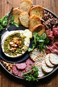 a platter filled with bread, crackers and meats