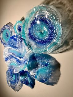 two blue and white glass vases sitting next to each other