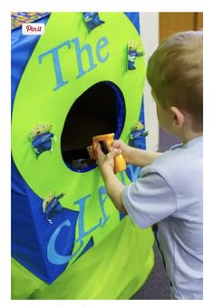 a young boy playing with a toy in front of a blue and green play tent