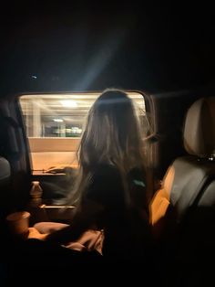 a woman sitting in the back seat of a car