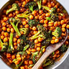 broccoli and chickpeas in a pan with a wooden spoon