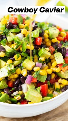 a white bowl filled with black beans, corn and avocado salad dressing being drizzled over it