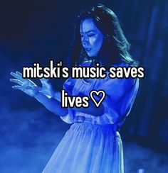 a woman in a blue dress holding her hands out with the words mittski's music saves lives