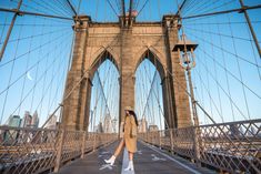 a woman walking across a bridge in new york city