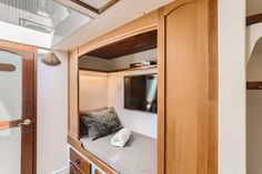 the inside of a small boat with a bed and pillows on it's side