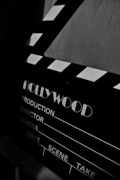 a black and white photo of a movie clapper with the hollywood logo on it