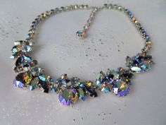 GORGEOUS vintage 50s signed necklace, Triad. This is a stunning necklace with the most sparkling crystal glass stones in a midnight blue, light blue, champagne, and flashing ab faceted stones-just so eye catching! The beautiful stones are set in a silver tone metal . The necklace measures about 17.5 inches in length and being about .75 inches wide. In wonderful condition sparkling stones, ready to wear and enjoy adding to your fine vintage jewelry collection. The images fail to capture the full Party Crystal Necklaces With Sparkling Stones, Round Crystal Necklaces With Sparkling Stones For Party, Party Crystal Multi-stone Necklace, Party Multi-stone Crystal Necklace, Crystal Multi-stone Necklace For Parties, Silver Multi-stone Necklace For Parties, Vera Wang Jewelry, Blue Champagne, Vintage Rhinestone Jewelry