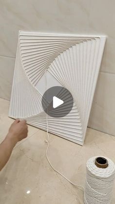 a person is working on a ceiling fan with white thread and spools next to it