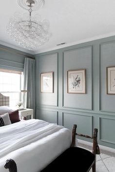 a bedroom with blue walls and white bedding