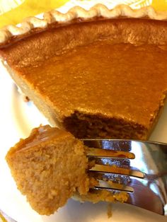 a piece of pumpkin pie on a plate with a fork next to it and a slice missing