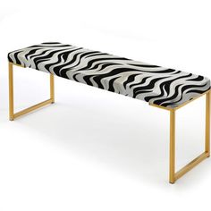 a zebra print bench sitting on top of a metal frame legs with a wooden leg