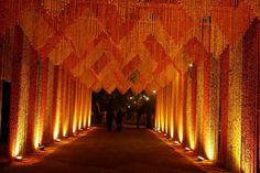 the walkway is lined with rows of orange and white lights that are hanging from the ceiling