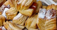 pastries are piled on top of each other with powdered sugar