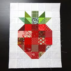 a patchwork quilt with an apple on the top and green leaves on the bottom