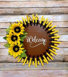 a welcome sign with sunflowers in the center on a wooden background that says welcome