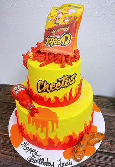 a three tiered cake decorated with candy bar and cheetos on the top