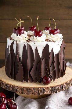 a cake with white frosting and chocolate icing, cherries on the top