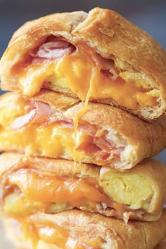 two ham and cheese sandwiches stacked on top of each other with melted cheese being drizzled over them