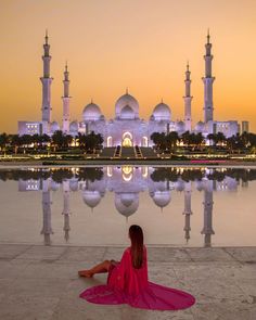 a woman sitting on the ground in front of a building