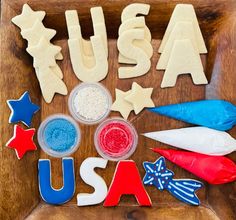 the word usa spelled out in letters and shapes on a wooden tray with patriotic decorations