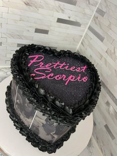 a heart shaped cake sitting on top of a white table next to a tiled wall