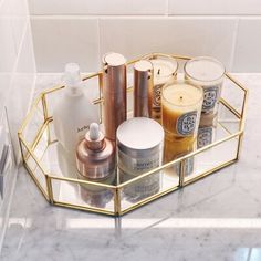 a bathroom shelf with various beauty products on it, including candles and lotion bottles