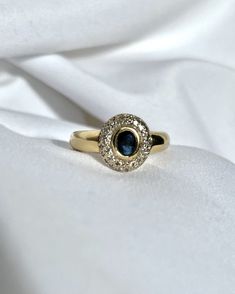 a close up view of a ring on a white cloth with the fabric in the background