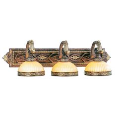 three light bathroom vanity fixture with gold glass shades and ornate carvings on the back wall