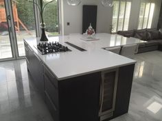 a kitchen with an island, stove and couches in the backround area