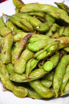 a white plate topped with green beans on top of a table