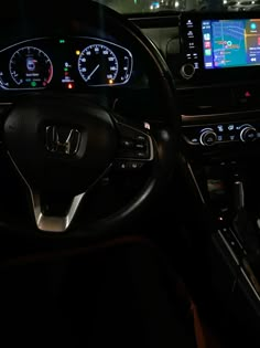 the interior of a car with various gauges and dash lights at night, including an iphone