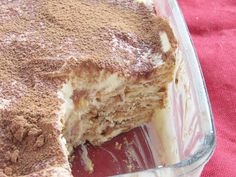 a cake in a glass dish on a red cloth