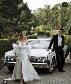 a man and woman standing next to a car