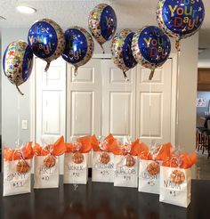 balloons and gift bags with congratulations messages on them