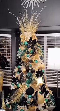 a christmas tree decorated with black, gold and green ornaments