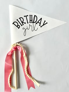 a pink ribbon tied to a white birthday flag