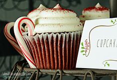 cupcakes with white frosting and red sprinkles are sitting on a wire rack