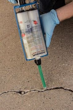 a person in blue gloves is holding a water heater and plugged into the ground