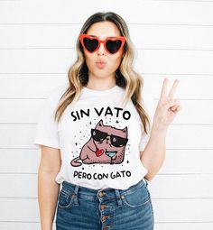 Sin vato pero con gato shirt, Valentines gift, Spanish gift, Dia de San Valentin, Latina shirt, Latina gift, Spanish Valentines, Español This classic unisex jersey short sleeve tee fits like a well-loved favorite. Soft cotton and quality print make users fall in love with it over and over again. These t-shirts have-ribbed knit collars to bolster shaping. The shoulders are tapered for a better fit over time. Dual side seams hold the garment's shape for longer.  .: Made with 100% Airlume combed an Novelty Letter Print Tops As Gift, Novelty Tops With Funny Text As Gift, Novelty Tops With Funny Text For Gifts, Funny Print Shirt As Gift, Fun Shirt With Funny Print For Gift, Funny Summer Tops As Gift, White Novelty Tops As Gift, White Novelty Tops For Gifts, White Novelty Tops As A Gift