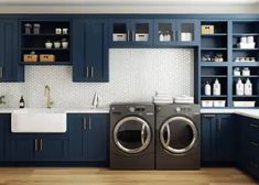 a washer and dryer in a kitchen with blue cabinets